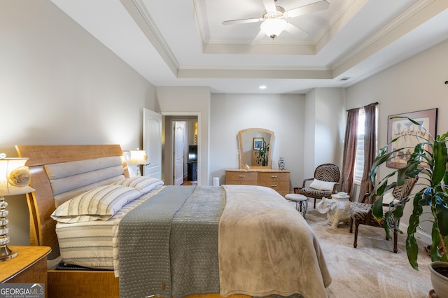 bedroom with ceiling fan, light carpet, and a tray ceiling