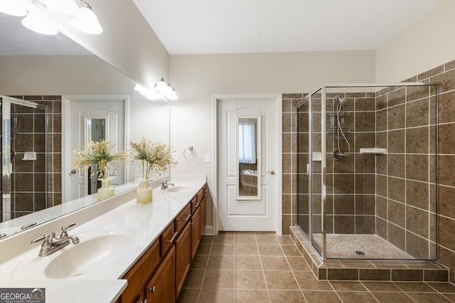 bathroom with tile patterned flooring, vanity, and tiled shower