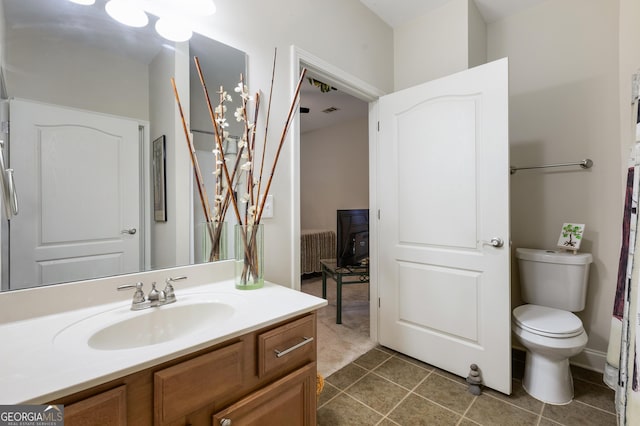 bathroom with tile patterned flooring, radiator heating unit, vanity, and toilet