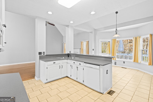 kitchen featuring kitchen peninsula, dishwasher, sink, decorative light fixtures, and white cabinetry