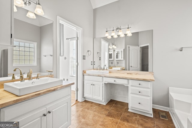 bathroom with a tub to relax in and vanity