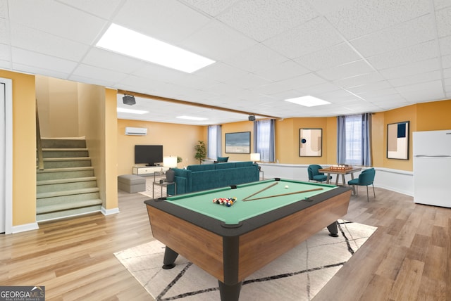 game room with light hardwood / wood-style floors, a drop ceiling, billiards, and a wall mounted AC