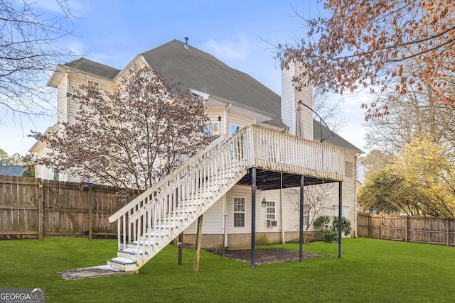 rear view of property with a wooden deck and a lawn