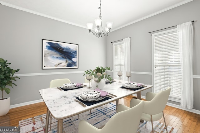 dining area featuring crown molding, hardwood / wood-style floors, and a notable chandelier