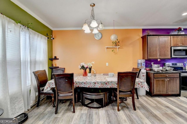 dining space featuring light hardwood / wood-style flooring, ornamental molding, and a notable chandelier