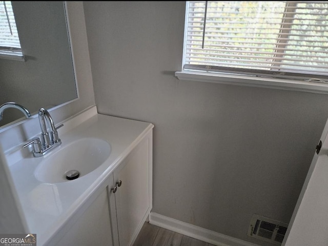 bathroom with a wealth of natural light, vanity, and hardwood / wood-style flooring