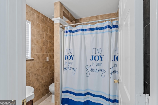 bathroom with a shower with shower curtain, tile walls, and toilet