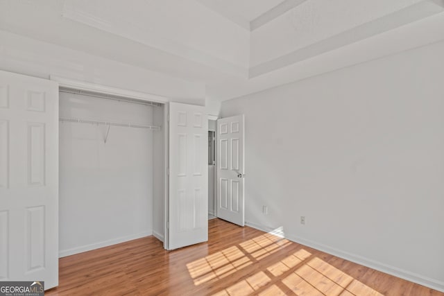 unfurnished bedroom featuring hardwood / wood-style floors and a closet