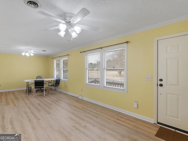 dining room featuring a textured ceiling, light hardwood / wood-style floors, ceiling fan, and crown molding