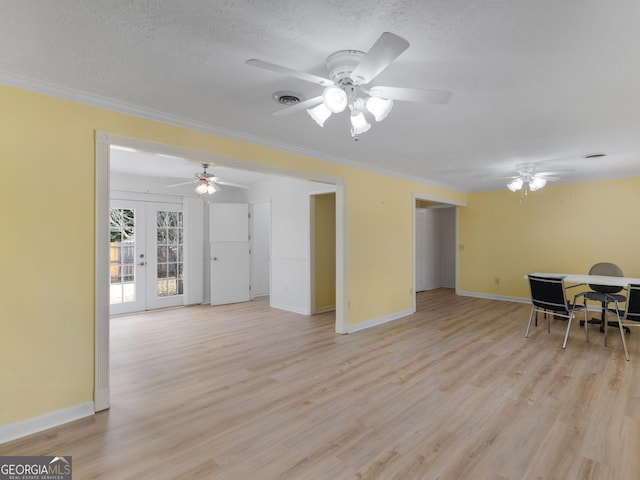 unfurnished living room featuring crown molding, french doors, light hardwood / wood-style floors, and a textured ceiling