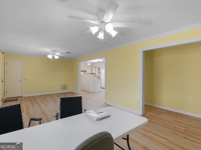 office space with ceiling fan, light wood-type flooring, and ornamental molding