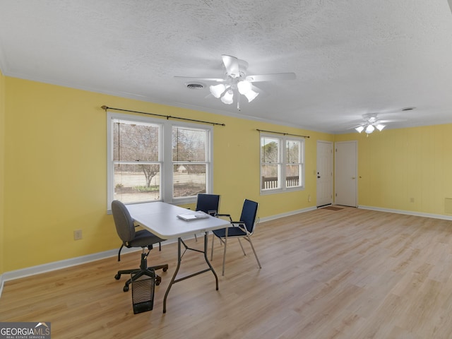 office area featuring a textured ceiling, light hardwood / wood-style flooring, ceiling fan, and crown molding