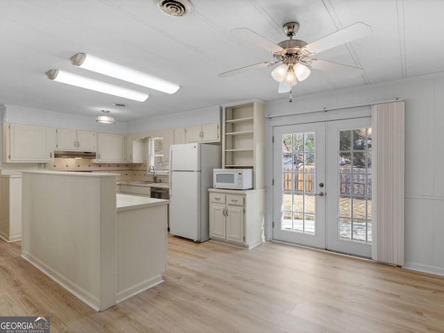 kitchen featuring ceiling fan, french doors, white appliances, a kitchen island, and light wood-type flooring