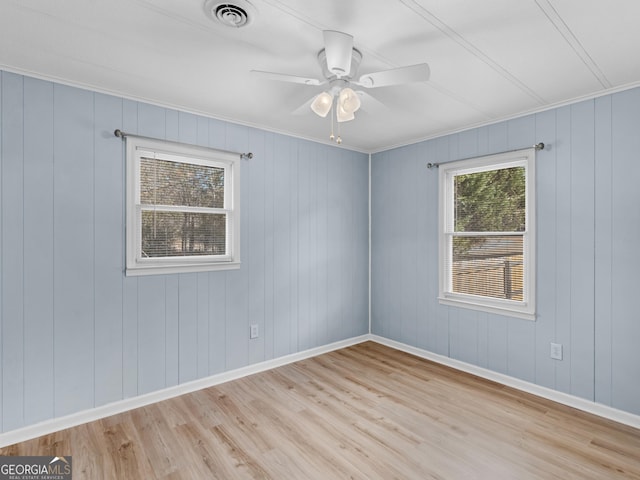 empty room with ceiling fan, light hardwood / wood-style floors, and crown molding