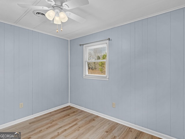 empty room featuring ceiling fan, light hardwood / wood-style floors, and ornamental molding