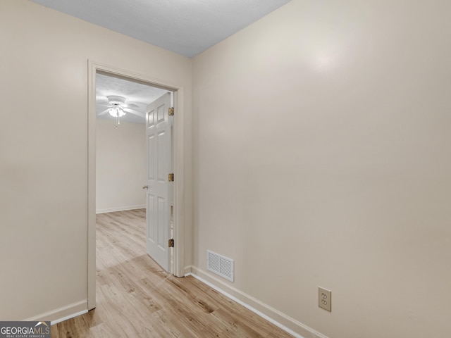 hall featuring a textured ceiling and light hardwood / wood-style floors