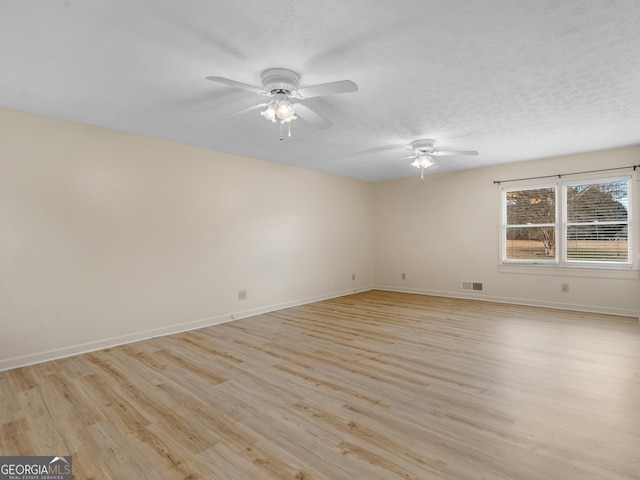 spare room featuring ceiling fan, light hardwood / wood-style floors, and a textured ceiling