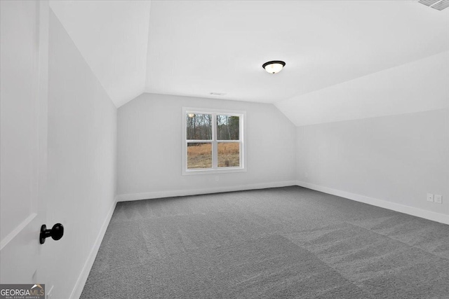 additional living space featuring lofted ceiling and carpet floors