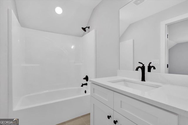 bathroom featuring vanity, tile patterned floors, vaulted ceiling, and  shower combination