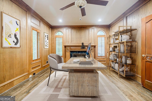 office featuring ceiling fan, a fireplace, and wooden walls