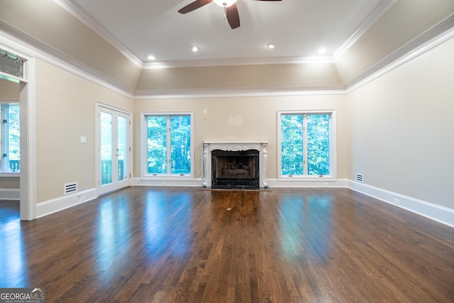 unfurnished living room featuring plenty of natural light, a raised ceiling, a premium fireplace, and crown molding