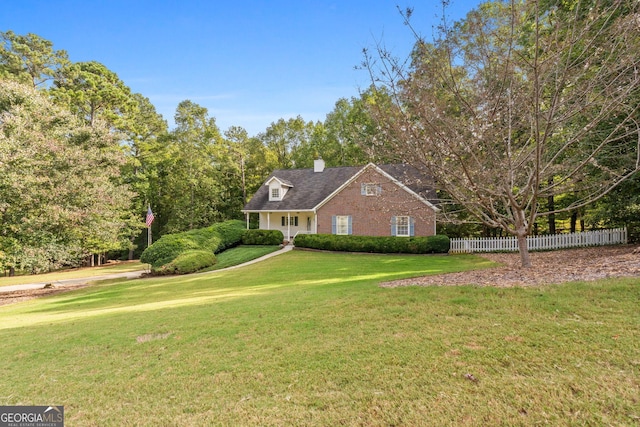 cape cod-style house with a front yard