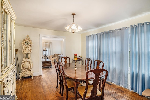 dining space featuring dark hardwood / wood-style floors and an inviting chandelier