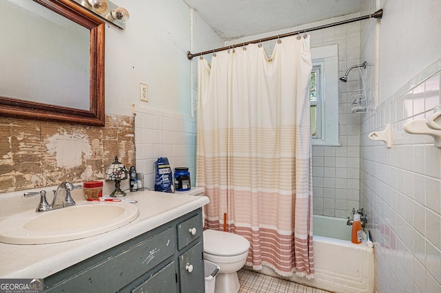 full bathroom featuring tile patterned floors, vanity, shower / tub combo with curtain, tile walls, and toilet