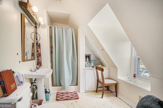 bathroom featuring a shower with curtain, lofted ceiling, and sink