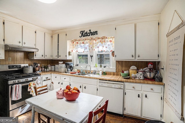 kitchen with white dishwasher, sink, stainless steel gas range, dark hardwood / wood-style flooring, and white cabinetry