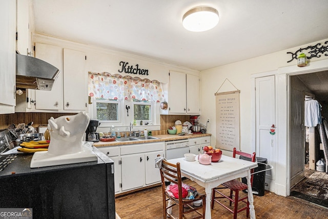 kitchen with dark wood-type flooring, sink, white cabinets, and extractor fan