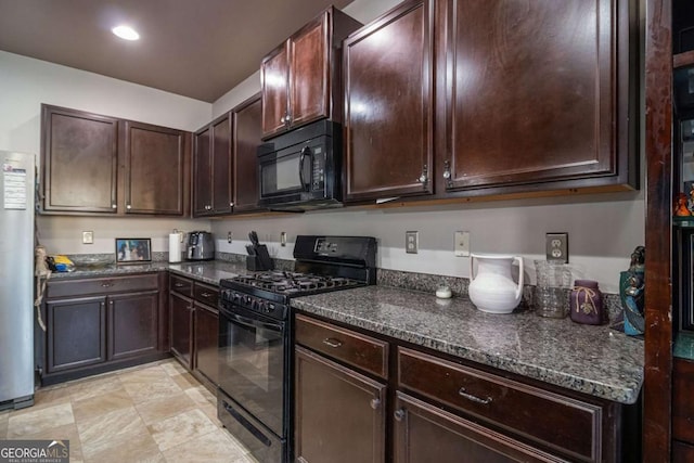 kitchen with dark brown cabinetry, dark stone countertops, and black appliances