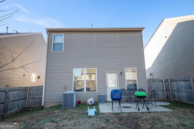 back of house featuring central air condition unit, a patio area, and a yard