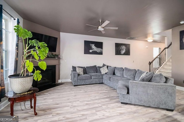 living room with light hardwood / wood-style flooring and ceiling fan