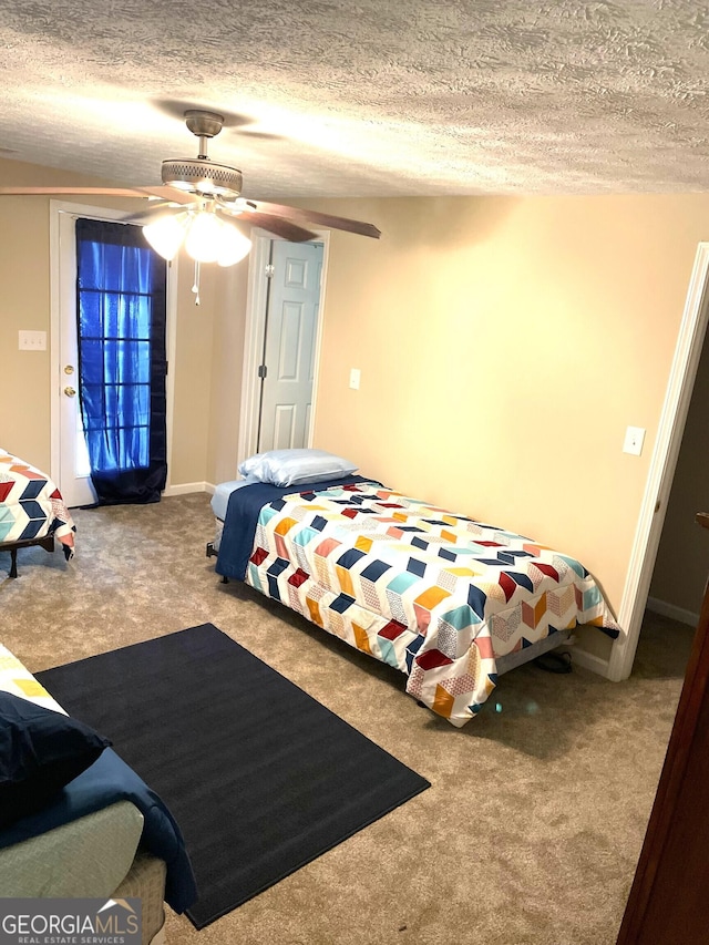 carpeted bedroom with ceiling fan and a textured ceiling