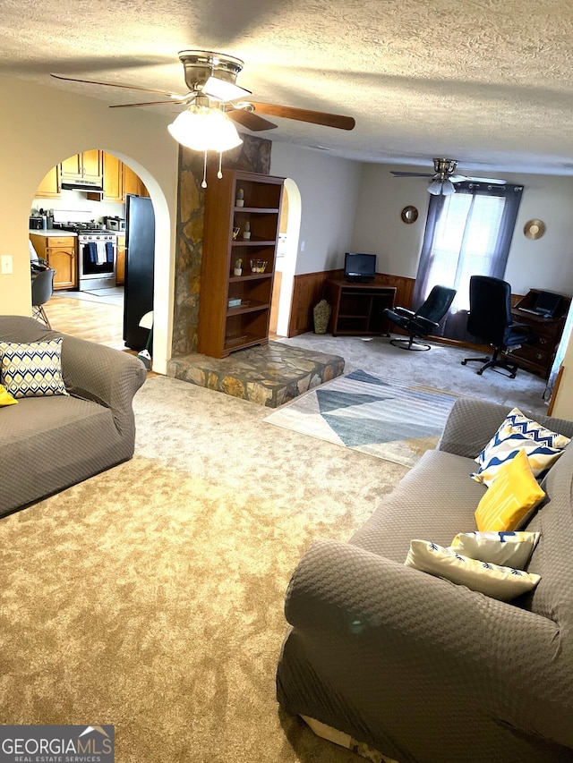 carpeted living room with wood walls and a textured ceiling