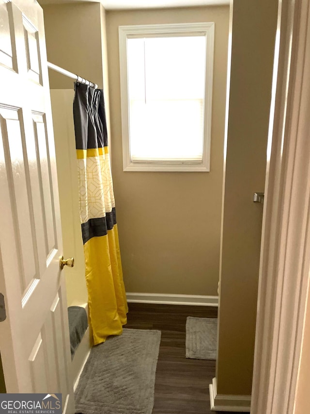 bathroom with shower / bath combo and hardwood / wood-style flooring