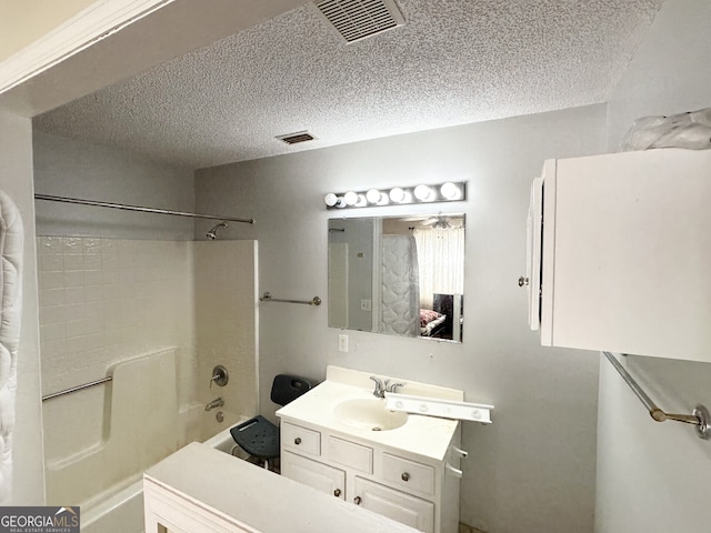 bathroom with vanity, a textured ceiling, and shower / washtub combination