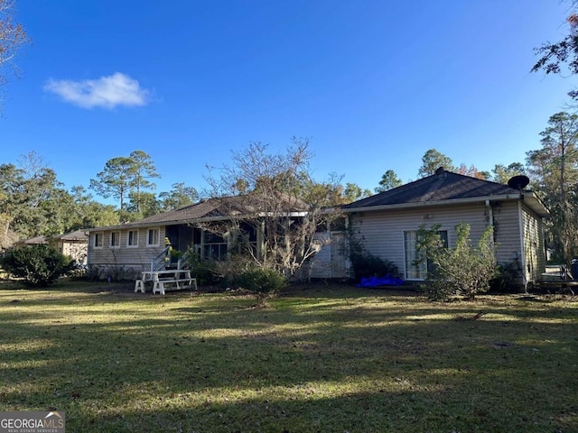 back of property featuring a lawn