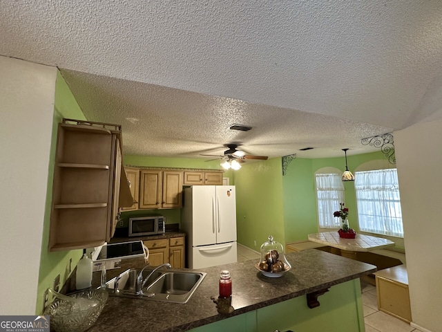 kitchen with white refrigerator, sink, ceiling fan, light tile patterned floors, and kitchen peninsula