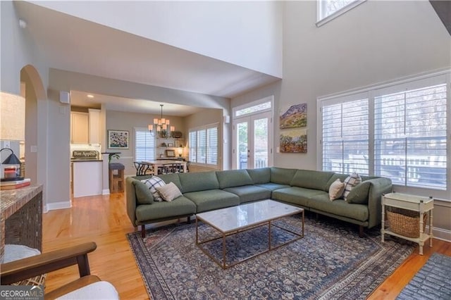 living room with light hardwood / wood-style floors and an inviting chandelier