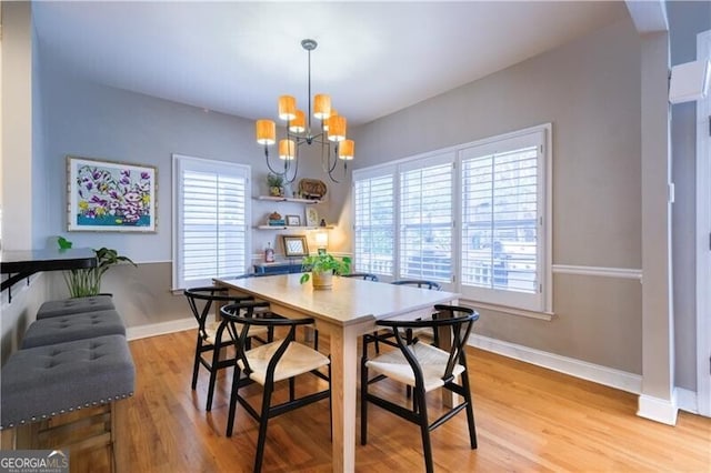 dining room featuring light hardwood / wood-style flooring, plenty of natural light, and an inviting chandelier