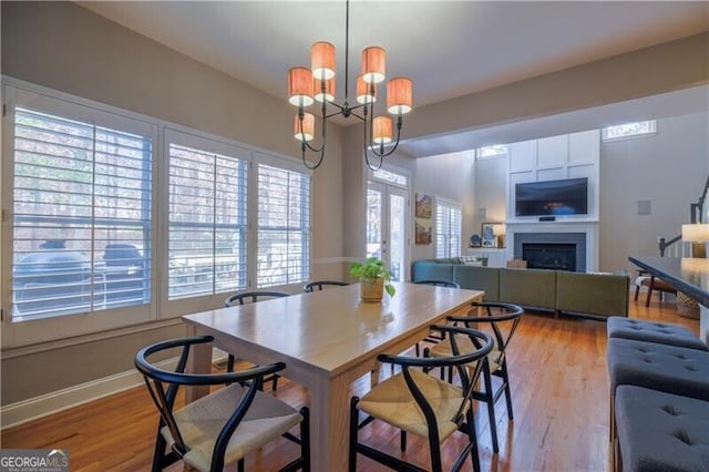 dining room with plenty of natural light, light hardwood / wood-style floors, and an inviting chandelier