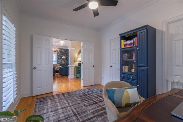 interior space with wood-type flooring, ceiling fan with notable chandelier, and a healthy amount of sunlight