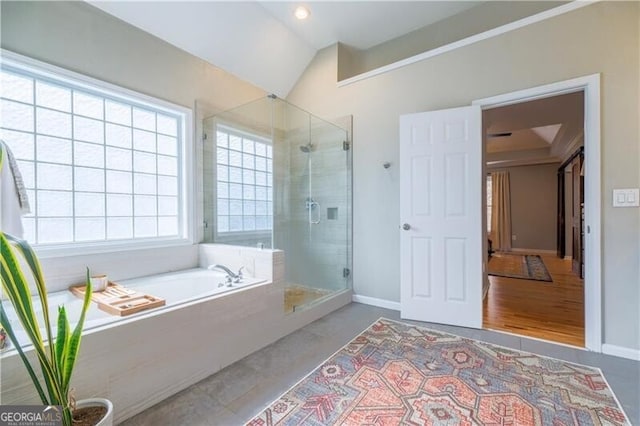 bathroom featuring independent shower and bath and vaulted ceiling