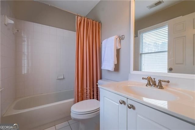 full bathroom with tile patterned floors, shower / bath combo with shower curtain, vanity, and toilet