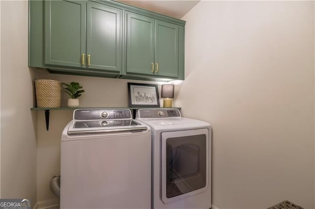 washroom with washer and clothes dryer and cabinets