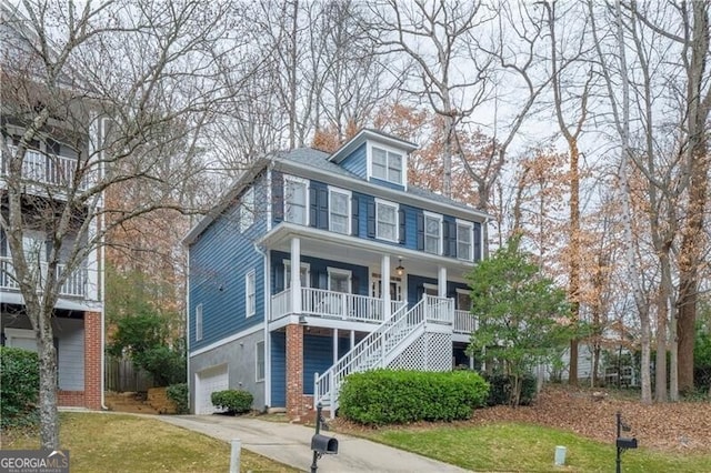 view of front of home with covered porch, a front yard, and a garage