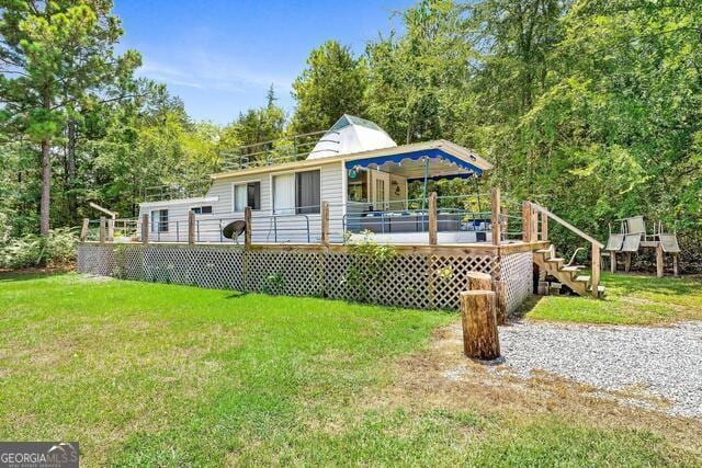 back of property with a lawn and a wooden deck