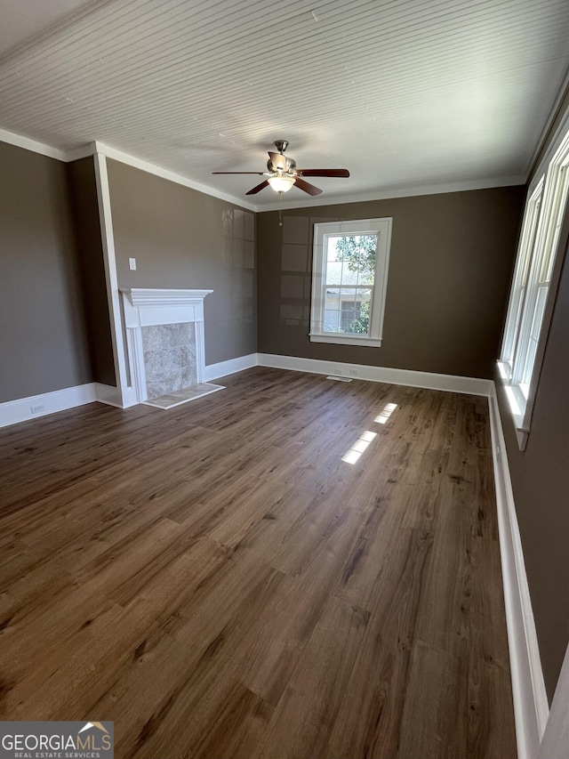 unfurnished living room with hardwood / wood-style floors, ceiling fan, ornamental molding, and a premium fireplace